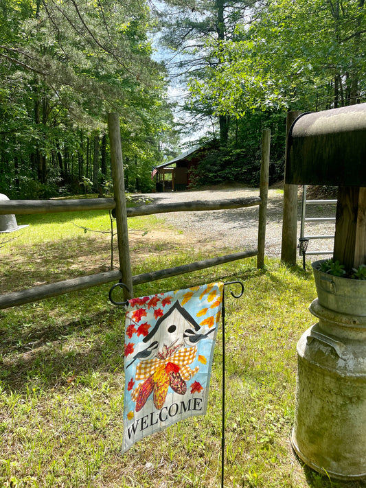 cabin with welcome flag at the front of image