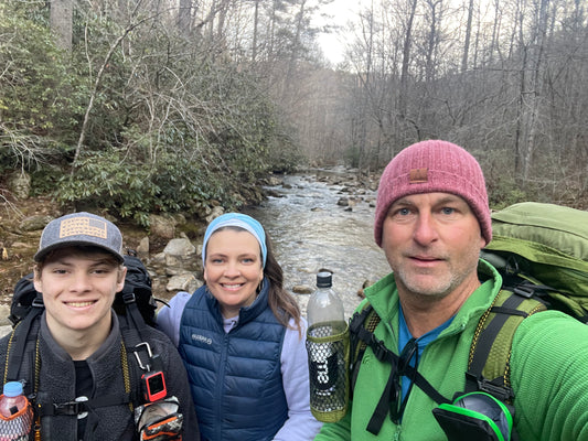 Man woman and teenager in front of a creek hiking