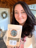 Woman holding a package with a label and decorative wreath in the background