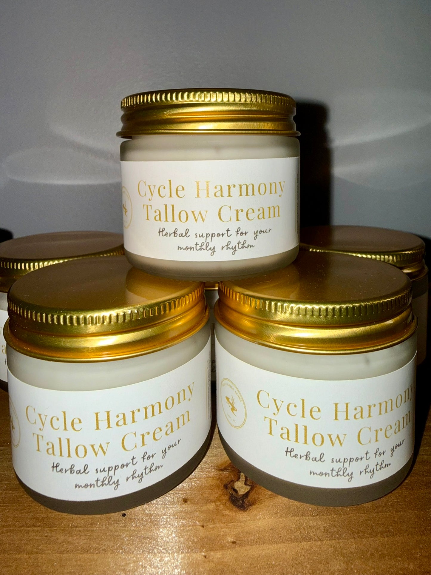 Jars of Cycle Harmony Tallow Cream on a wooden surface with a neutral background