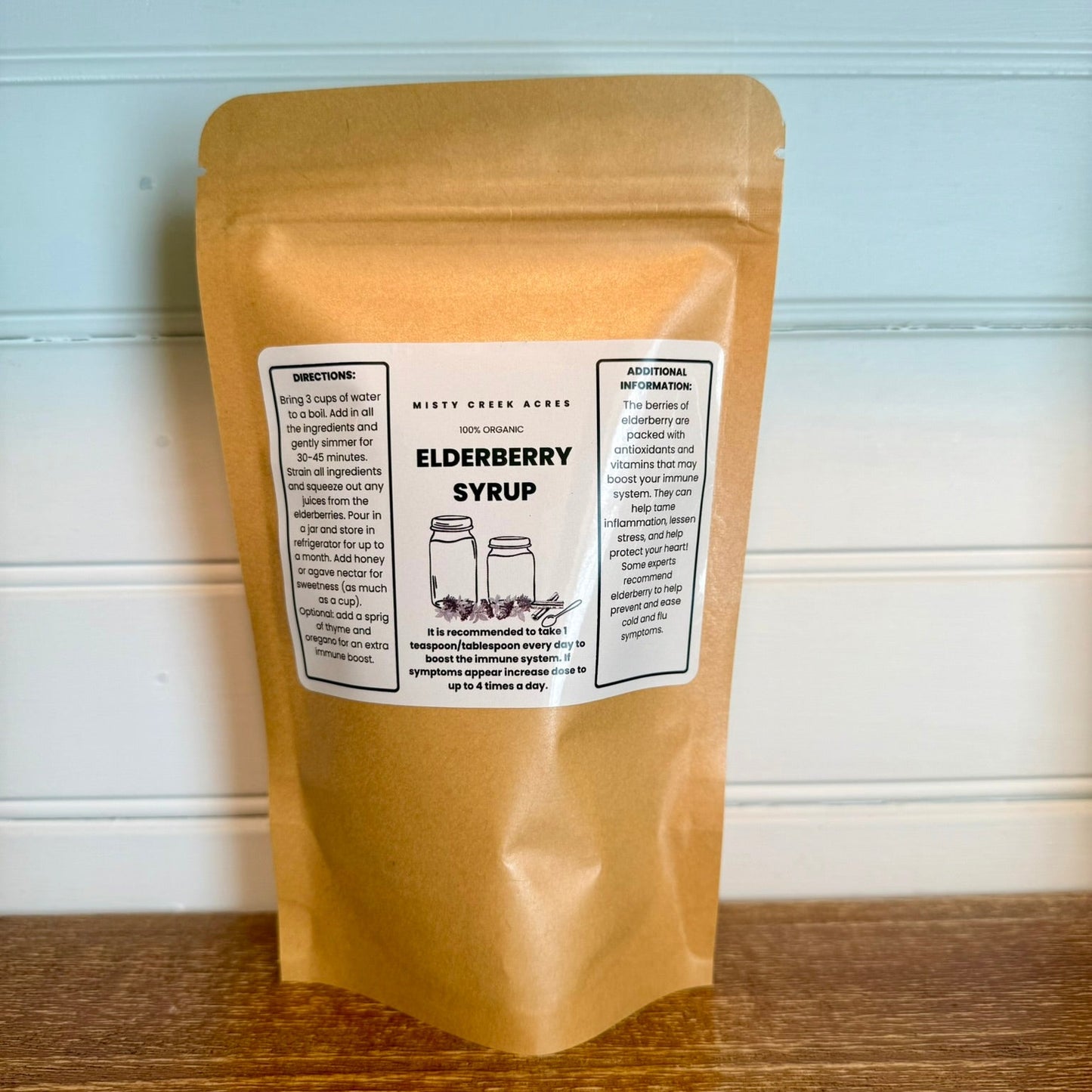 Kraft paper packaging of elderberry syrup with a label on a wooden surface.