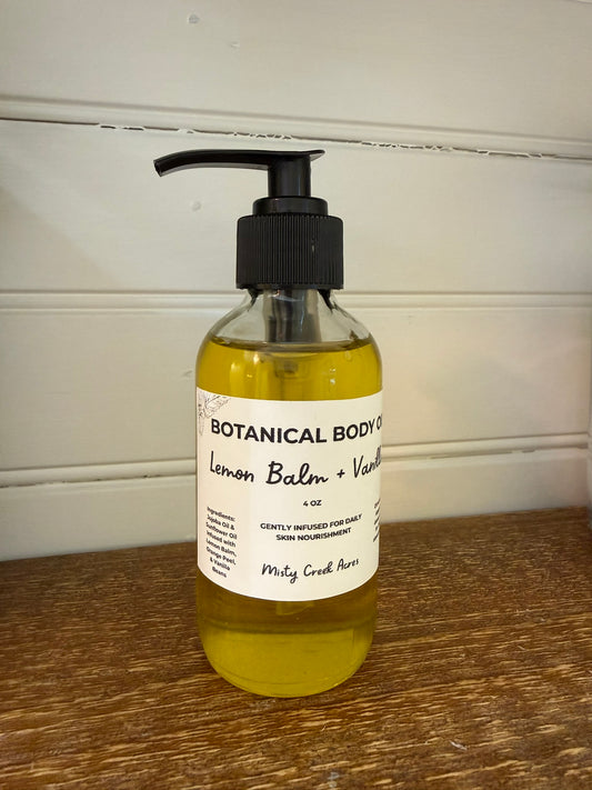 Bottle of Botanical Body Co. Lemon Balm & Vanilla soap on a wooden surface with a white wall background.