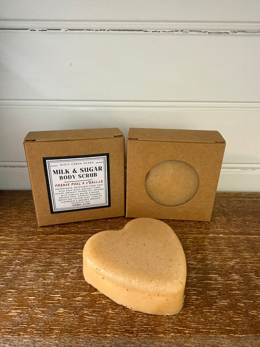 Heart-shaped body scrub with packaging on a wooden surface