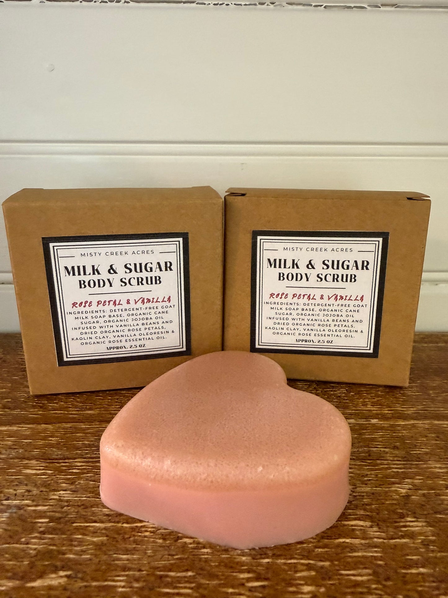 Milk and sugar body scrub with packaging on a wooden surface