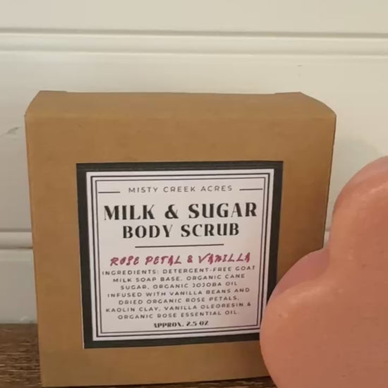 Heart-shaped body scrub and packaging on a wooden surface with a white wall background