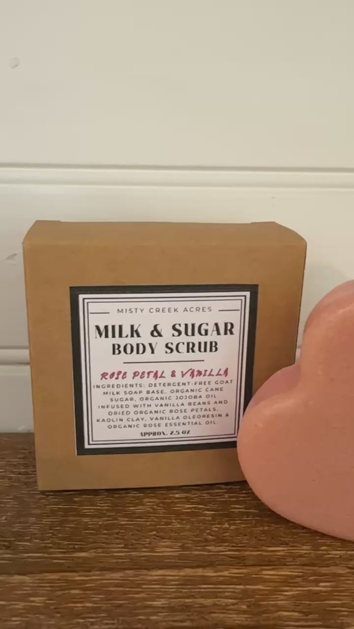 Heart-shaped body scrub and packaging on a wooden surface with a white wall background