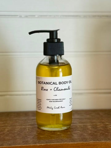 Bottle of botanical body oil with a pump on a wooden surface