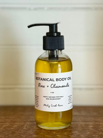 Bottle of botanical body oil with a pump on a wooden surface