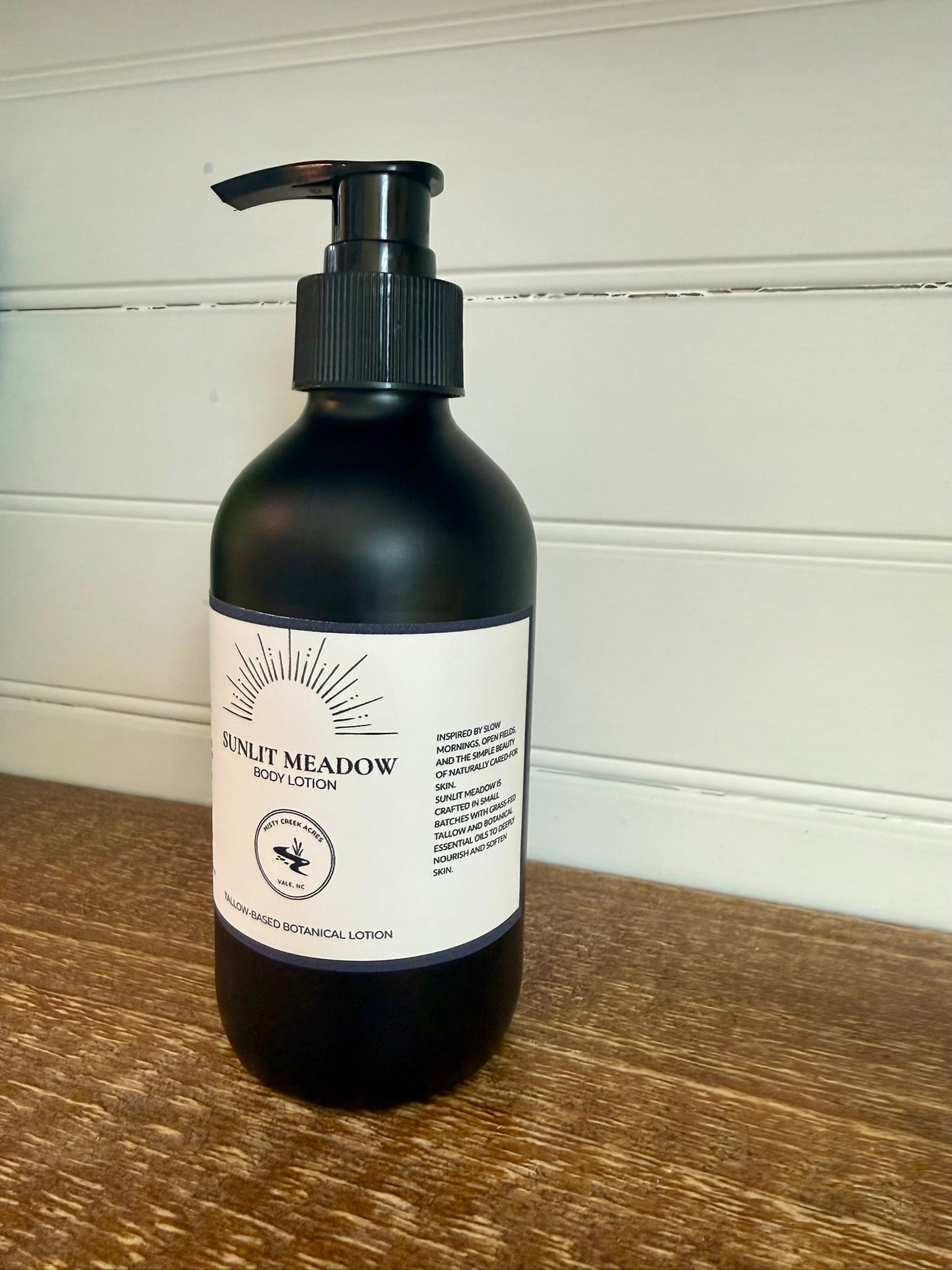 Black lotion bottle with a label on a wooden surface