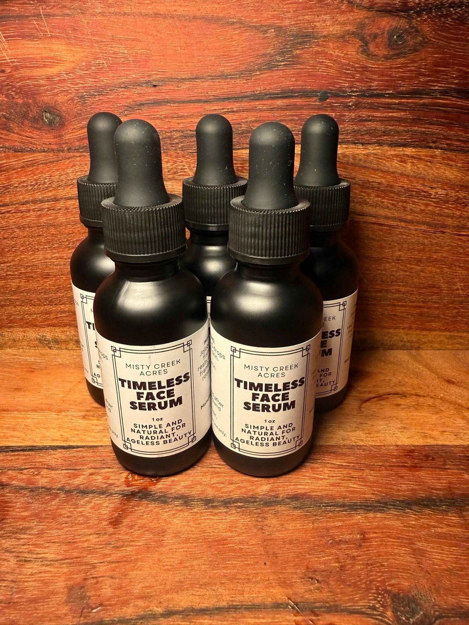 Bottles of 'Timeless Face Serum' on a wooden surface