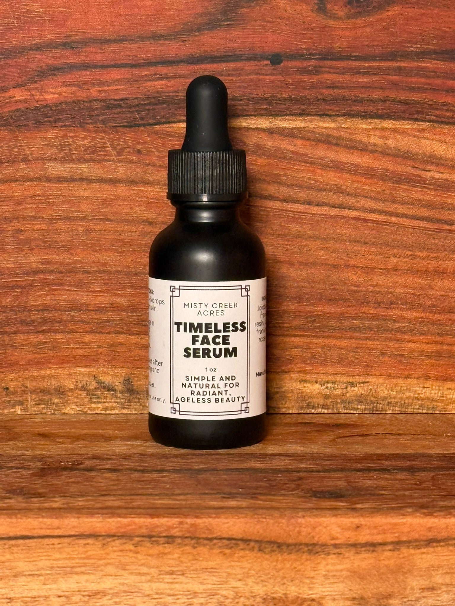 Black bottle of 'Timeless Face Serum' on a wooden surface